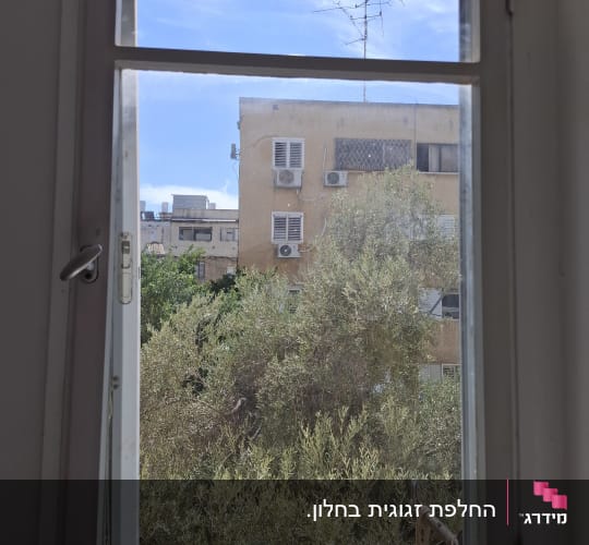 זכוכית שקופה מותקנת בחלון ביתי הצופה לנוף חיצוני